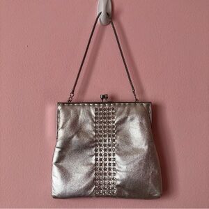 Silver metallic clutch with rhinestone detailing.
